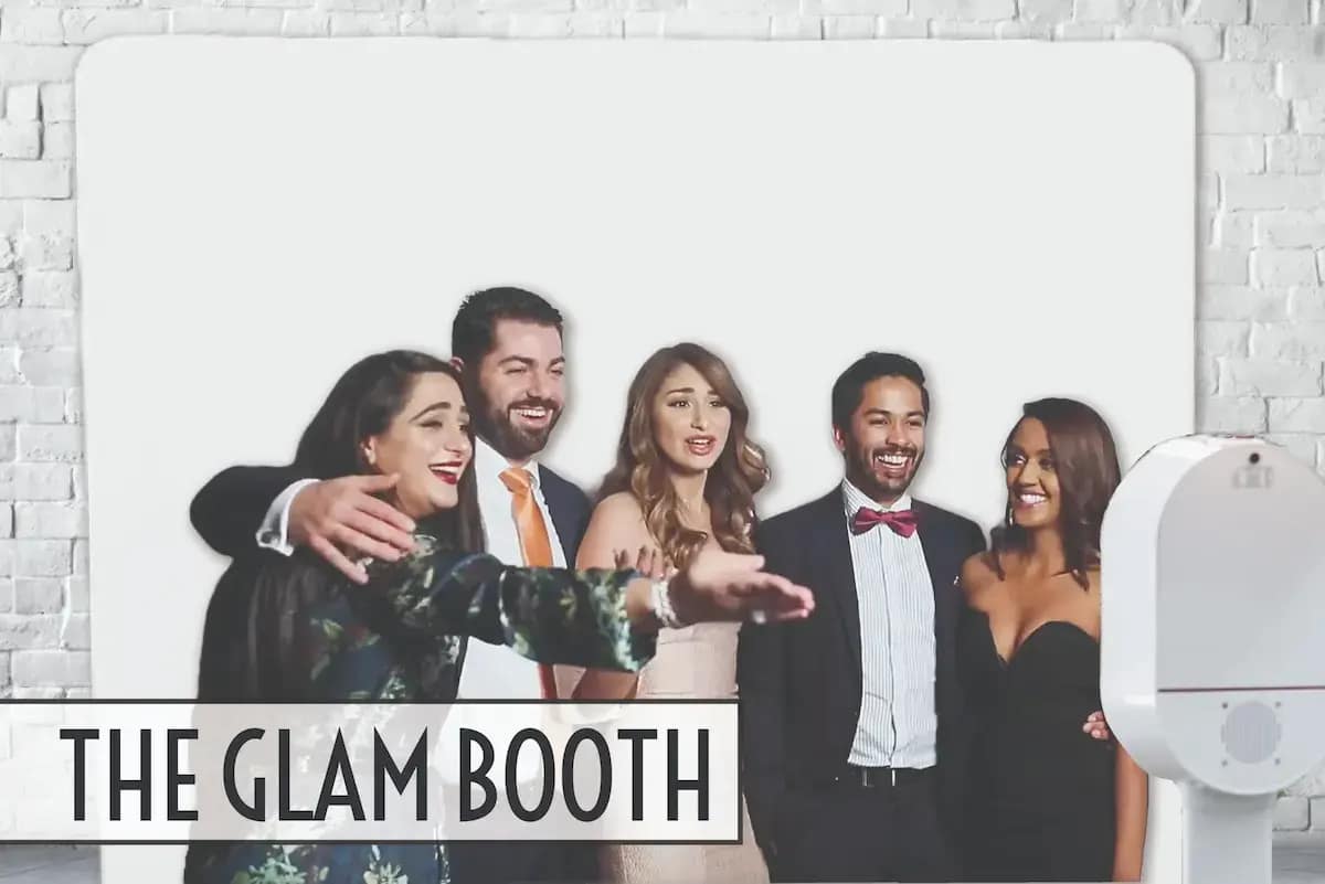 Wedding guests posing beside the white Glam Booth