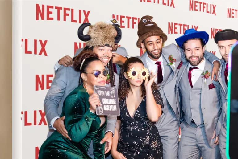 Corporate event guests posing with props at a branded photo booth