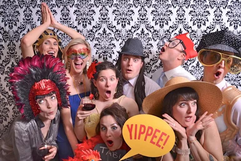 Large group celebrating with colorful photo booth props