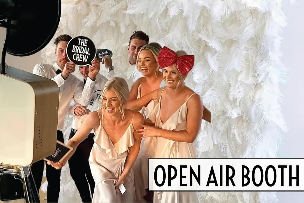 Bridal party using an Open Air Booth with a white floral backdrop