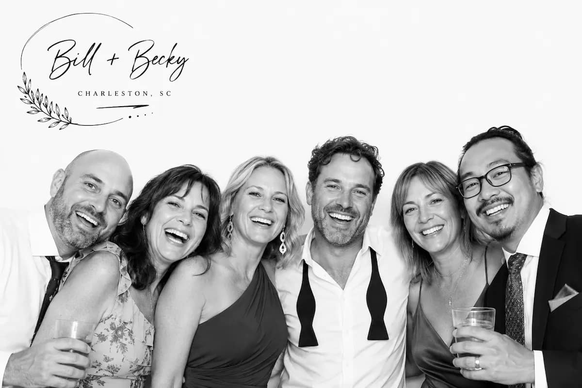 Six wedding guests smiling in a black-and-white Glam Booth portrait
